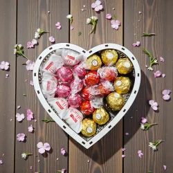 Wnętrze pudełka w kształcie serca z pralinkami Ferrero Rocher, Raffaello i Lindor ułożonymi w kompozycji