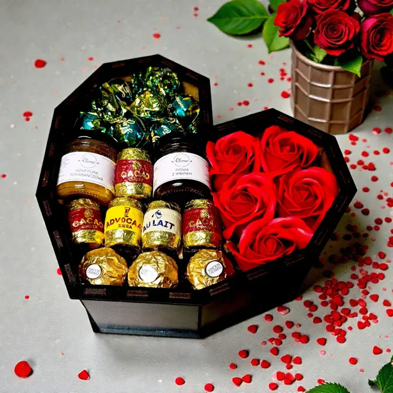 Wnętrze czarnego pudełka w kształcie serca z czekoladkami, słoiczkami i mydlanymi różami