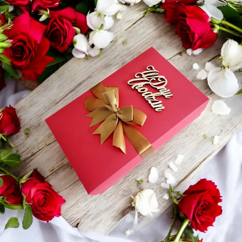 Czerwone pudełko urodzinowe ze złotą wstążką i napisem