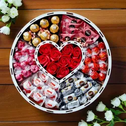 Wnętrze okrągłego pudełka urodzinowego z czerwonymi różami i słodyczami