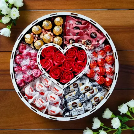 Wnętrze okrągłego pudełka urodzinowego z czerwonymi różami i słodyczami
