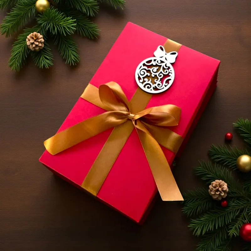 Czerwone pudełko świąteczne ze złotą wstążką i drewnianą bombką