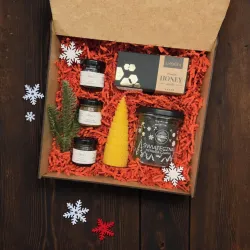 Wnętrze białego pudełka świątecznego z herbatą, miodem i pomarańczowymi dodatkami