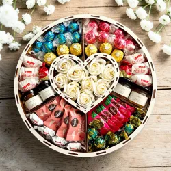 Wnętrze ślubnego pudełka z białymi różami, sercem i słodką kompozycją