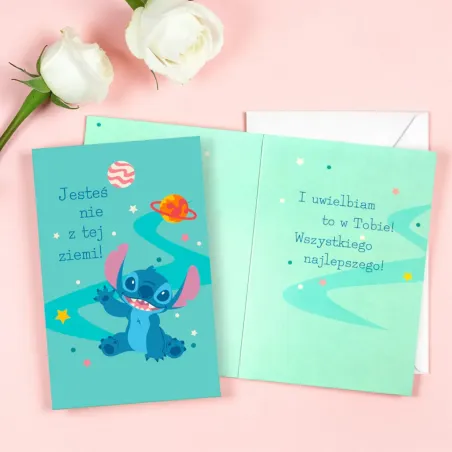 Karnet ze Stitchem, kosmicznym motywem i białą kopertą.