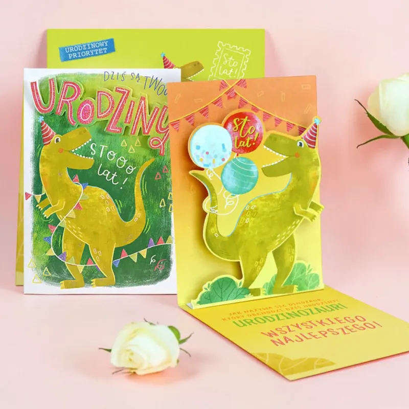 Karnet pop-up z dinozaurem, zieloną kopertą i urodzinowymi życzeniami.
