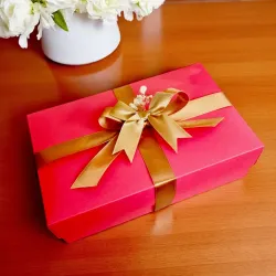 Zamknięte czerwone pudełko przewiązane złotą wstążką