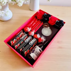 Otwarta zawartość czerwonego pudełka ze słodyczami i mydłem