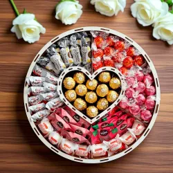 Wnętrze okrągłego pudełka z przegródkami i słodyczami widocznymi pod wieczkiem