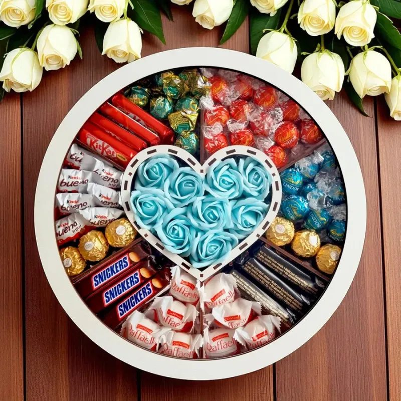 Zamknięte białe okrągłe pudełko z przezroczystym wieczkiem widziane z góry z niebieskimi różami