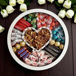 Zamknięte białe okrągłe pudełko z przezroczystym wieczkiem widziane z góry ze złotymi różami