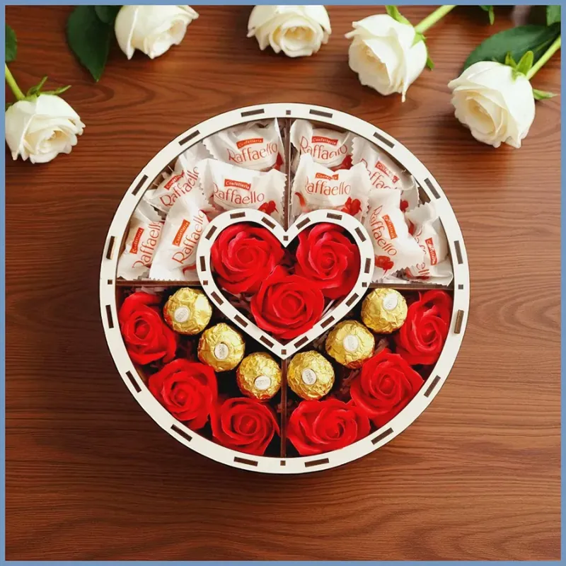 Zawartość pudełka widoczne słodycze i róże czerwone