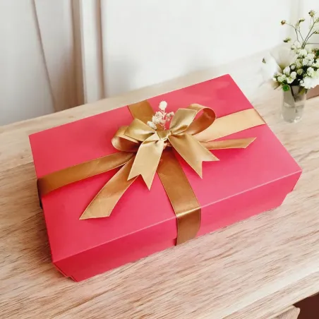 Zamknięte czerwone pudełko przewiązane złotą wstążką