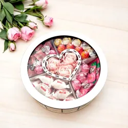 Zamknięte białe okrągłe pudełko z przezroczystą pokrywką i widoczną kompozycją w środku