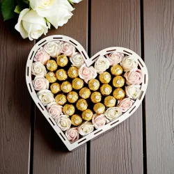 Wnętrze dużego pudełka w kształcie serca z pralinkami Ferrero Rocher i jasnymi różami mydlanymi dookoła