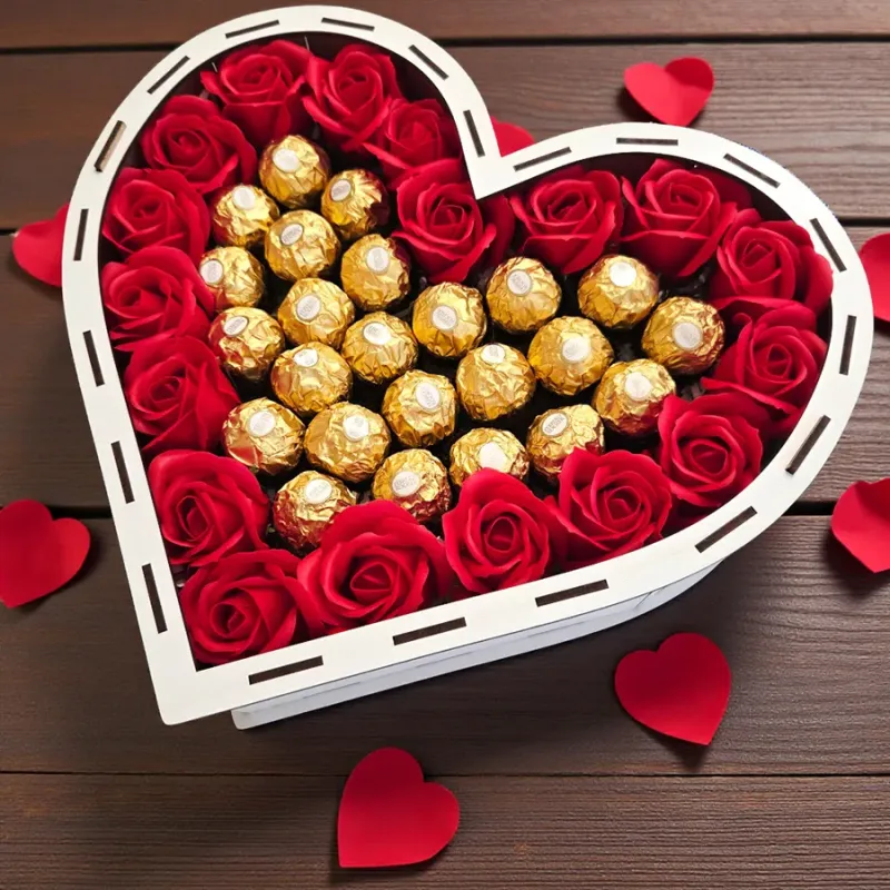 Wnętrze pudełka w kształcie serca z pralinkami Ferrero Rocher i czerwonymi różami mydlanymi ułożonymi dookoła
