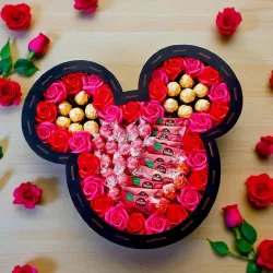 Wnętrze dużego pudełka z charakterystycznymi uszami, czerwonymi różami mydlanymi i słodyczami