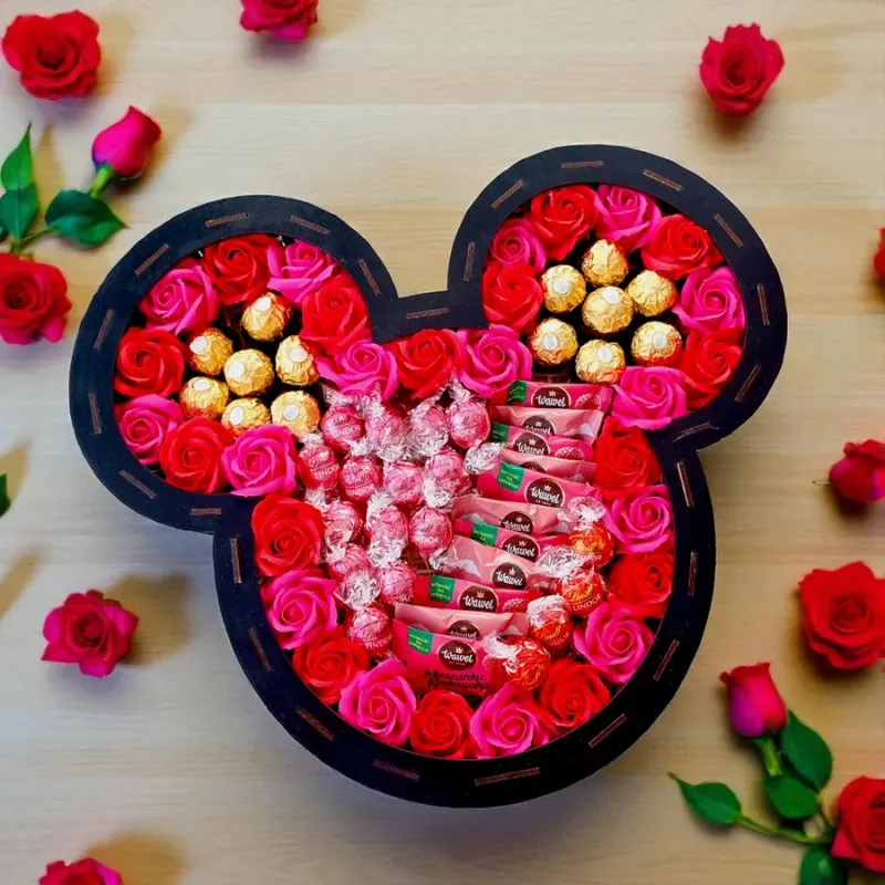 Wnętrze dużego pudełka z charakterystycznymi uszami, czerwonymi różami mydlanymi i słodyczami