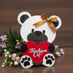 Zamknięte pudełko w kształcie misia z czerwonym sercem, napisem „Kocham Cię” i złotą kokardką