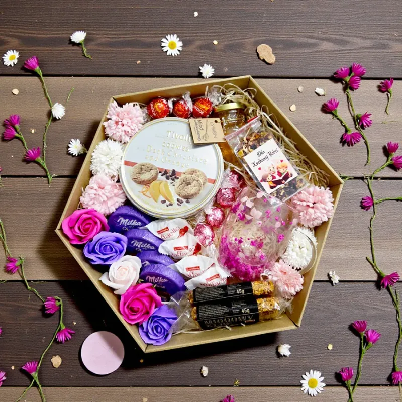 Wnętrze sześciokątnego brązowego pudełka z miodem, herbatą, słodyczami i dekoracyjnymi kwiatami